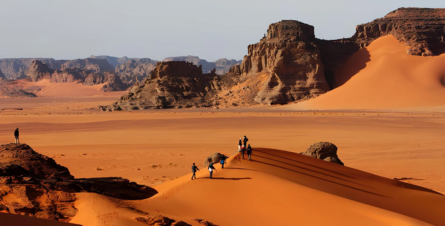 Des touristes sur les dunes du parc culturel du Tassili, près de Djanet en Algérie (Crédit : Ibrahim Djari, CC BY-SA 4.0)